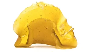 Buy Banana Shatter UK – Premium THC Concentrate on Black Surface with Glass Container
